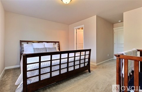 A bedroom with a large bed and a carpeted floor.