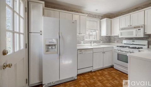 A kitchen with white appliances and cabinets.