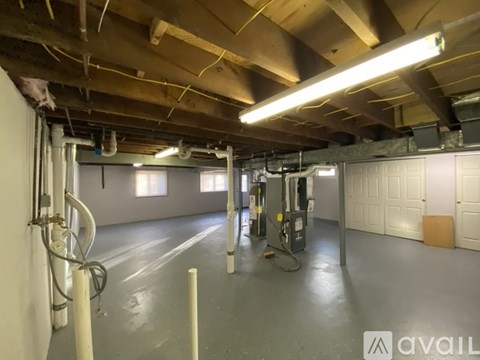 A spacious garage with a concrete floor and a ceiling with exposed beams.