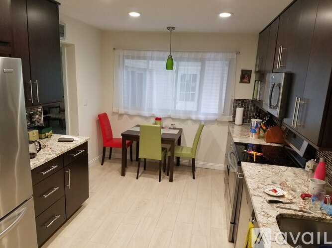 A kitchen with a table and chairs in the middle.