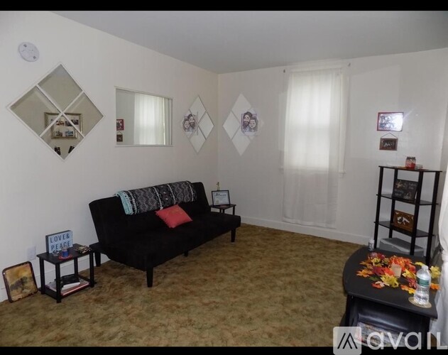 A living room with a black couch and a coffee table.