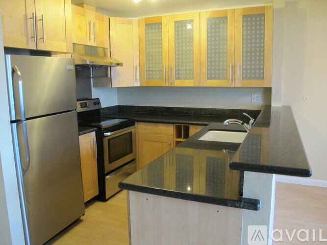 A kitchen with wooden cabinets and a black countertop.