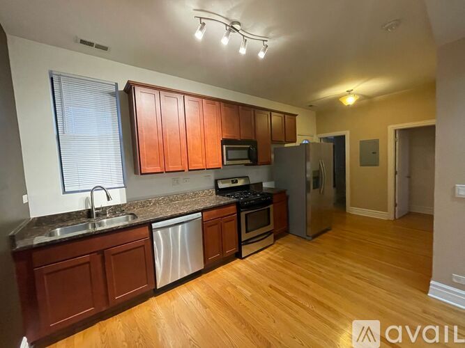 A kitchen with wooden cabinets and stainless steel appliances is available for rent.