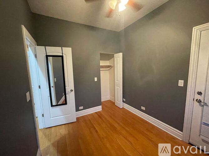 A room with a white door and a mirror on the wall.