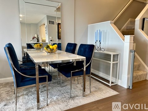 A dining room with a glass table and blue chairs.