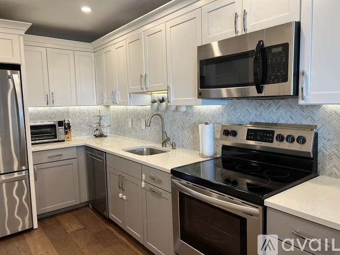 A kitchen with white cabinets and a black stove top oven.