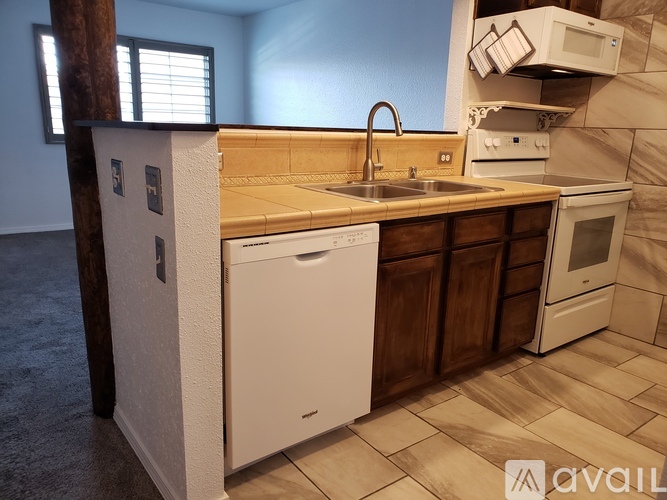 A kitchen with a white dishwasher and white oven.