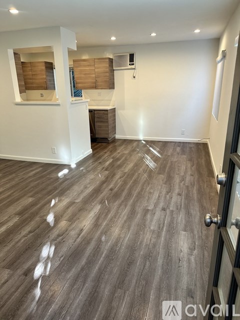 A room with wooden flooring and a white wall.