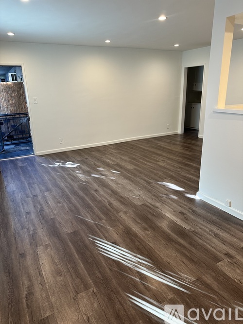 A room with wooden flooring and white walls.