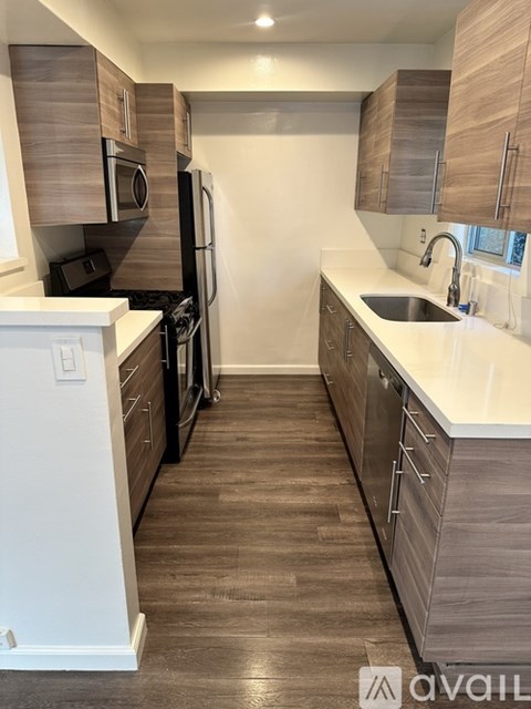 A kitchen with white appliances and wooden cabinets.