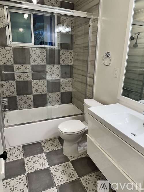 A bathroom with a toilet, sink, and shower.