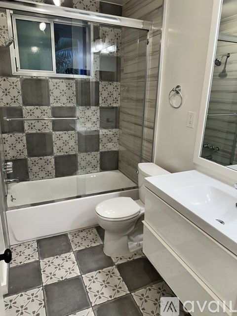 A bathroom with a toilet, sink, and shower.