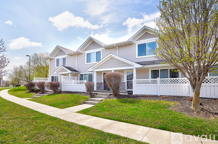 A house with a white fence and a tree in front.