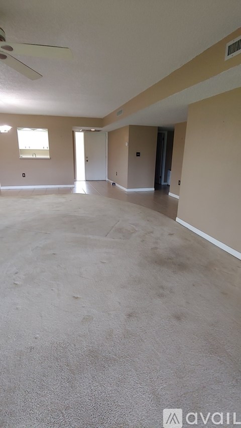 A spacious room with a fan and a window.
