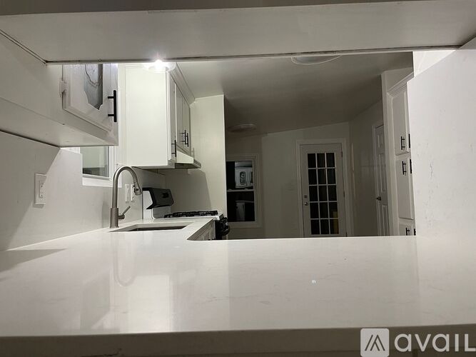 A kitchen with white cabinets and a countertop.