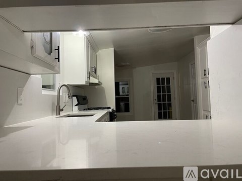 A kitchen with white cabinets and a countertop.