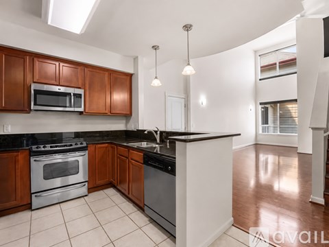 A kitchen with brown cabinets and a black countertop.