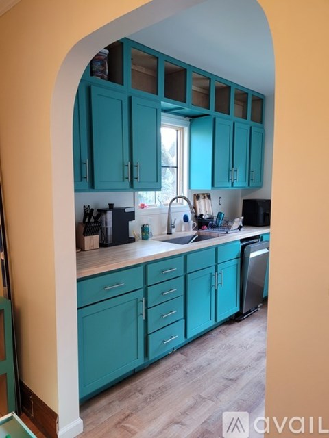 A kitchen with teal cabinets and a white countertop.