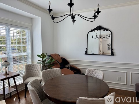 A dining room with a round table and chairs.