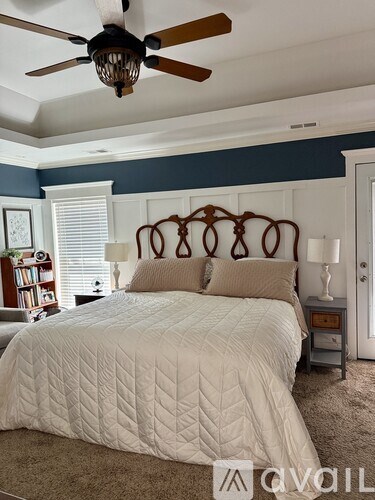 A bedroom with a large bed and a ceiling fan.