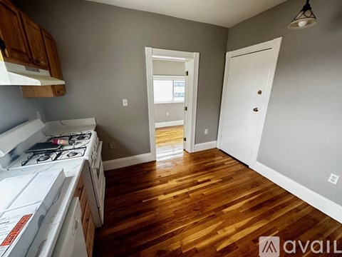 A kitchen with wooden floors and white appliances.