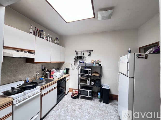 A kitchen with a stove top oven and a refrigerator.