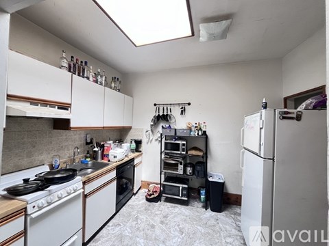 A kitchen with a stove top oven and a refrigerator.