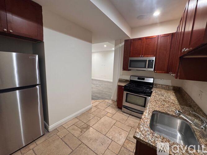 A kitchen with brown cabinets and a stainless steel refrigerator.