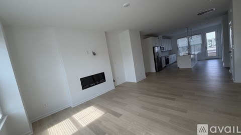 A spacious living room with a fireplace and wooden flooring.