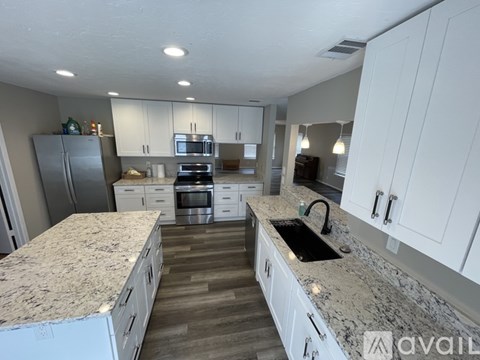 A kitchen with white cabinets and granite countertops.