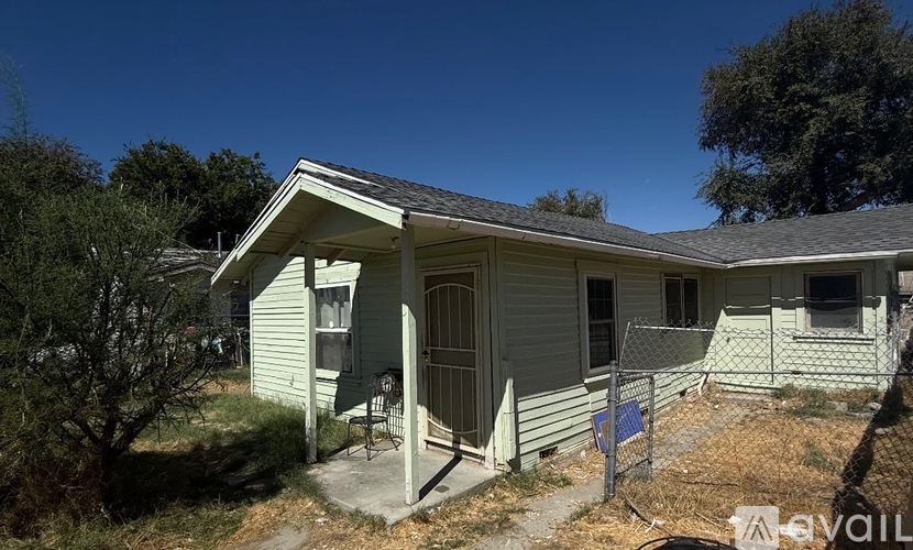 A house with a fence and a sign in front.