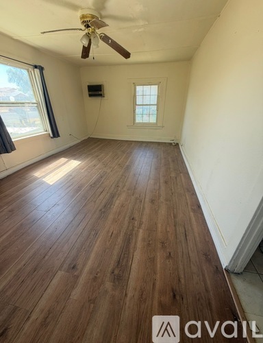 A room with wooden flooring and a ceiling fan.