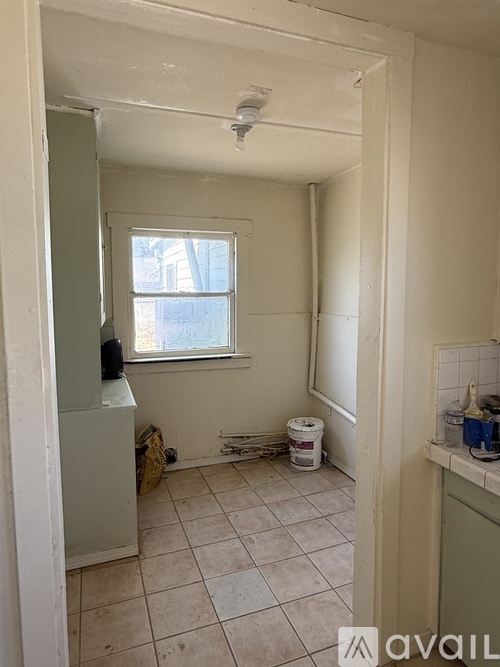 A room with a window and a tiled floor.