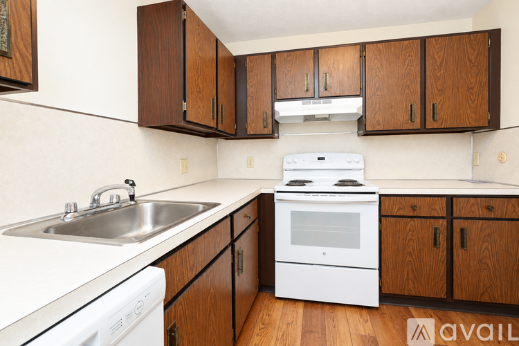 A kitchen with wooden cabinets and white appliances.