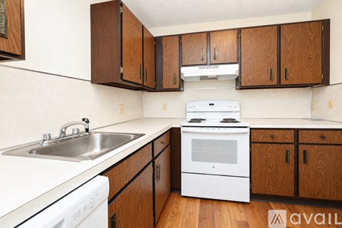 A kitchen with wooden cabinets and white appliances.