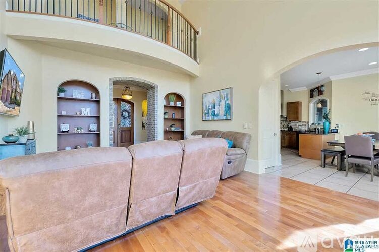 A living room with a large couch and a balcony.