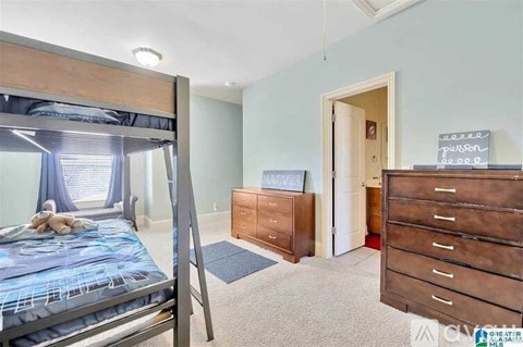 A bedroom with a bunk bed and a dresser.