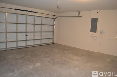 A spacious garage with a white door and a concrete floor.