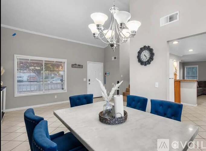 A dining room with a large table and blue chairs.