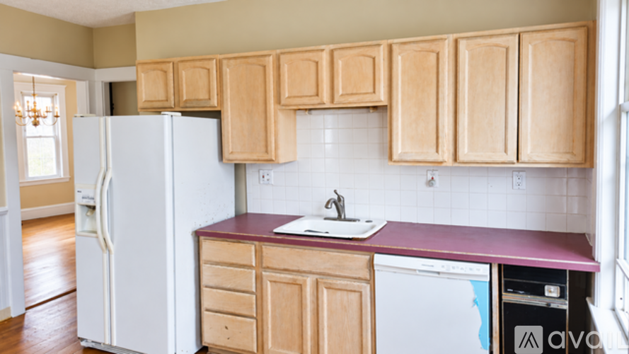 A kitchen with wooden cabinets and a white refrigerator.