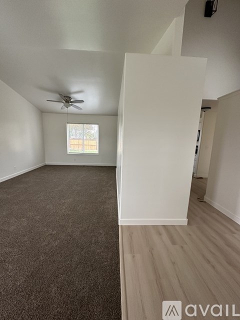 A room with a ceiling fan and a window with blinds.