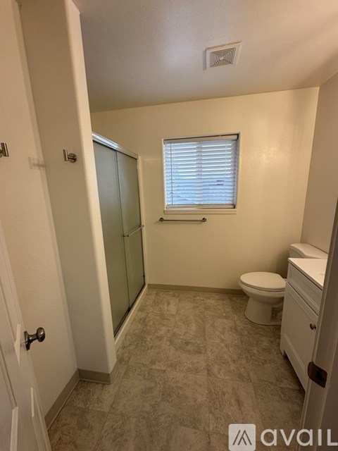 A bathroom with a toilet, sink, and shower.