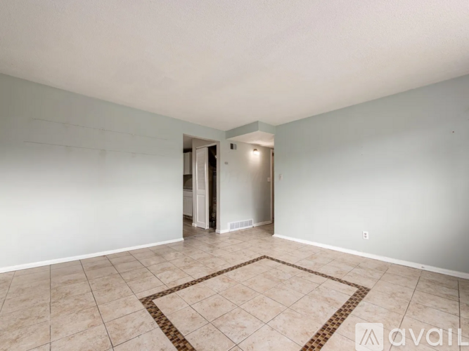 A room with a tiled floor and a rug in the middle.
