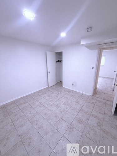 A room with a tiled floor and a doorway leading to another room.