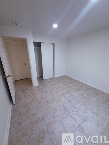 A room with a tiled floor and a door on the left.