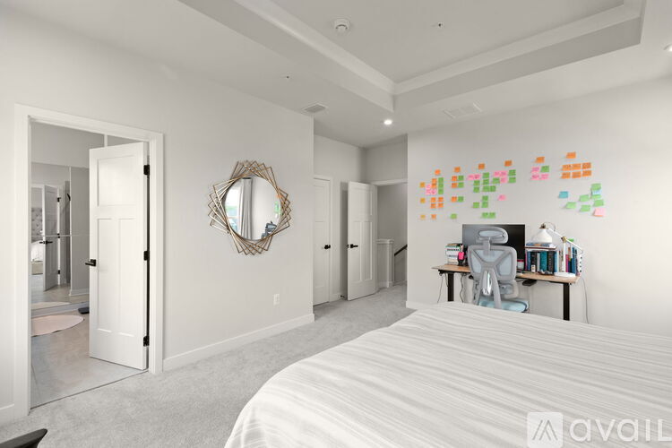 A bedroom with a large bed and a desk with a chair.