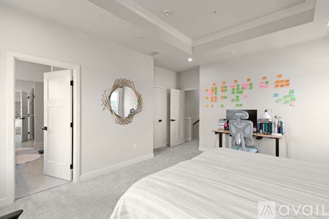 A bedroom with a large bed and a desk with a chair.