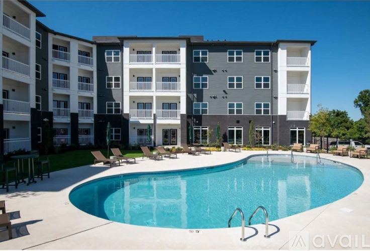 A large swimming pool is surrounded by apartment buildings.