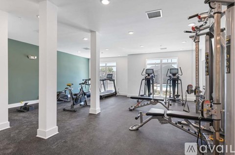 A gym with a row of exercise bikes and a row of weight machines.