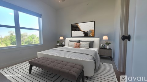 A bedroom with a large bed and a window overlooking a green landscape.